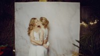 two brides kissing in front of a backdrop