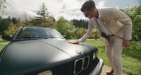 groom cleaning green bmw on wedding day