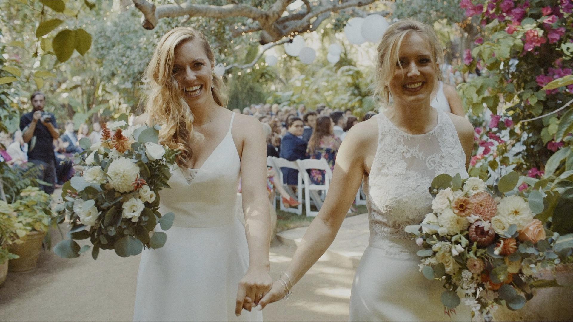 two brides holding hands after the wedding ceremony at holly farm
